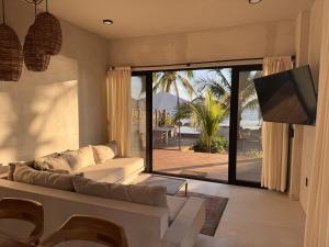 a living room with a couch and a large sliding glass door at Aldea Cayaco Villa A1 in La Manzanilla