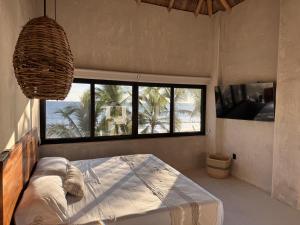 a bedroom with a bed in a room with windows at Aldea Cayaco Villa A1 in La Manzanilla