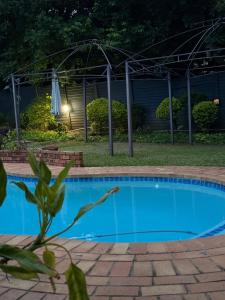 a swimming pool in a yard at night at Amira Boutique Villa in Empangeni +28 photos