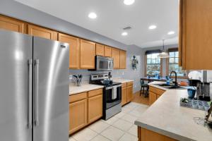a kitchen with wooden cabinets and a stainless steel refrigerator at Kindroot 5 in Tucson +26 photos