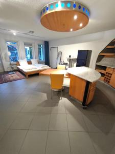a large room with a table and yellow chairs at D&D Guesthouse in Angelbachtal