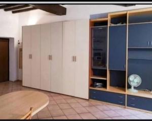 a large kitchen with white cabinets and a table at Va Pensiero Cuore di Parma in Parma