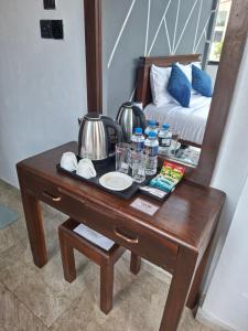 a wooden table with a mirror and a bed at Kandy City Inn in Kandy