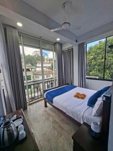 a bedroom with a bed and a large window at Kandy City Inn in Kandy