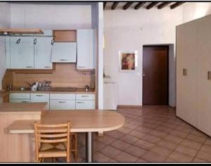 a kitchen with white cabinets and a wooden table at Va Pensiero Cuore di Parma in Parma