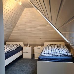 two beds in a room with two night stands at Nordseewohnung Strandloeper in Wittmund