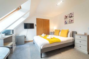 a bedroom with a bed with yellow sheets and yellow pillows at Ben View Room 3 in Fort William