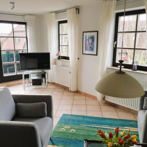 a living room with a couch and a tv at Nordseewohnung Strandloeper in Wittmund