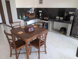 a kitchen with a wooden table and chairs at The Aurora in Ahangama