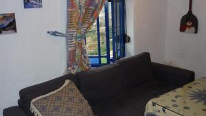 sala de estar con sofá y ventana en La Muralla, en Yunquera