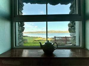 a tea pot sitting on a table in front of a window at Portmagee Seaside Cottages - Gannet in Portmagee