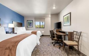 a hotel room with two beds and a desk at My Place Hotel-Shakopee, MN in Shakopee