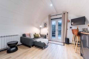 a living room with a couch and a tv at Apex Studio Pod and Jacuzzi Bath in Fort William