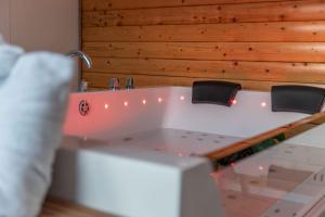 a white bathtub with two chairs in a room at Apex Studio Pod and Jacuzzi Bath in Fort William