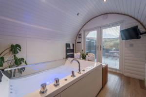 a large bathroom with a tub and a window at Apex Studio Pod and Jacuzzi Bath in Fort William +14 photos