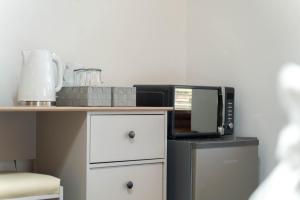 a kitchen with a counter with a microwave and a refrigerator at Ben View Room and Jacuzzi Bath in Fort William