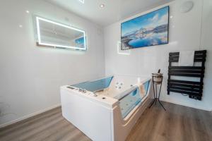 a bath tub in a white room with a window at Ben View Room and Jacuzzi Bath in Fort William