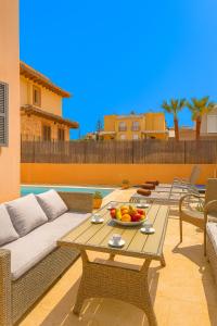 a patio with a table with a bowl of fruit on it at Can Angelica in Santa Margalida