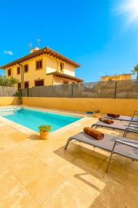 a swimming pool with a chaise lounge next to a house at Can Angelica in Santa Margalida
