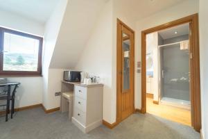 a room with a bathroom with a sink and a door at Ben View Room 4 in Fort William