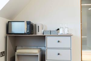 a desk with a microwave and a tv on it at Ben View Room 4 in Fort William