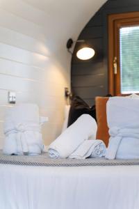 a pile of white towels sitting on a shelf at Ben View Pod and Jacuzzi Bath in Fort William