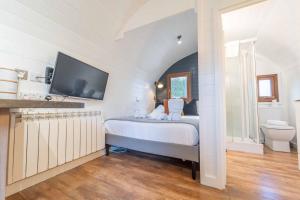 a bedroom with a bed and a tv on the wall at Ben View Pod and Jacuzzi Bath in Fort William