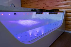 a bath tub with a purple counter top with lights at Ben View Pod and Jacuzzi Bath in Fort William