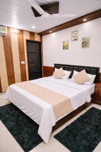 a bedroom with a large bed with white sheets and pillows at Hotel In Varanasi in Varanasi +5 photos