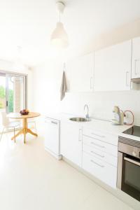 a kitchen with white cabinets and a table in it at Can Angelica in Santa Margalida