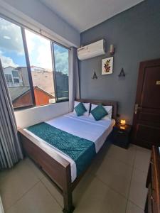 a bedroom with a bed with a large window at Kandy City Inn in Kandy +30 photos