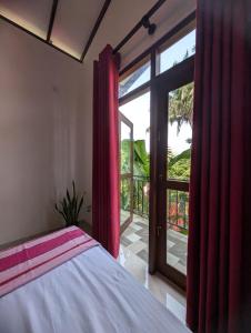 a bedroom with a bed and a large window at The Aurora in Ahangama