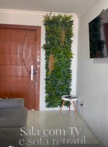 a living room with a door and a plant on the wall at Casa de temporada em Jacaraípe in Serra