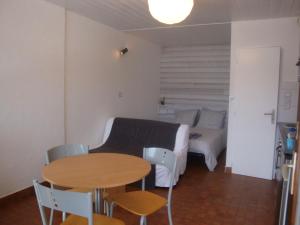 a living room with a bed and a table and chairs at Les Epinettes Studio Prairie in Gérardmer