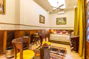 a bedroom with a bed and a table and chairs at Riad Habouba in Marrakesh
