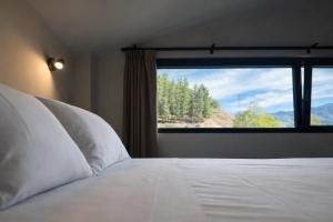 a bedroom with a white bed with a large window at El Balcón de Potes in Potes