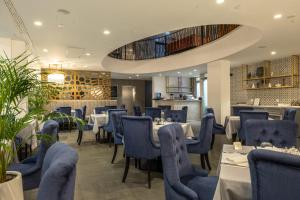 a restaurant with blue chairs and tables in a room at Royal Blue Hotel in Dubrovnik