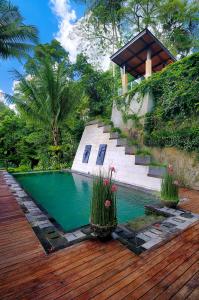 una piscina con 2 plantas en una terraza de madera en Villa Kalisha - Romantic, Seclusion in the heart of Nature, en Tegalalang