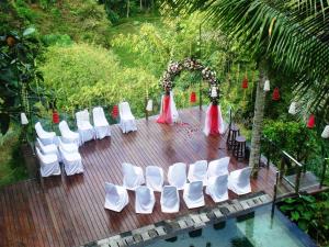 an outdoor wedding with white chairs and an arch at Villa Kalisha - Romantic, Seclusion in the heart of Nature in Tegalalang +49 photos