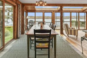 a dining room with a table and chairs and windows at Candlewood Isle in New Fairfield