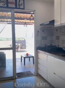 a kitchen with a sliding glass door to a patio at Casa de temporada em Jacaraípe in Serra