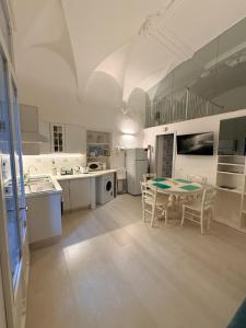a large white kitchen with a table and chairs at DUOMO26 BOUTIQUE APARTMENT in Desenzano del Garda +21 photos