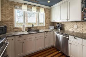a kitchen with white cabinets and a sink at Pine Creek Beach House in Fairfield +42 photos