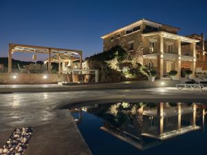 a house with a pool in front of a building at Astarte Villas - Arismari Villas in Vasilikos