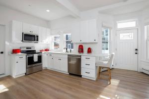 a white kitchen with white cabinets and red appliances at Harbor Haven, Apt #5, 3BR/2BA in Stamford