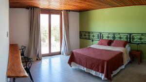 a bedroom with a bed and a green wall at Casa Canto do Bem-te-vi in Lençóis