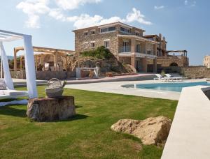 a villa with a swimming pool and a house at Astarte Villas - Arismari Villas in Vasilikos