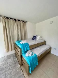 a bedroom with two twin beds and a window at Casa del Prado in Santa Marta +5 photos