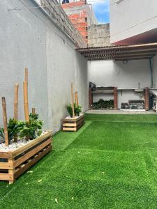 an outdoor patio with green grass and plants at Casa del Prado in Santa Marta