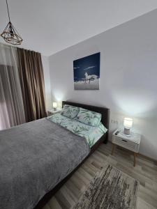 a bedroom with a bed and a night stand with two lamps at La Andrei in Bistriţa